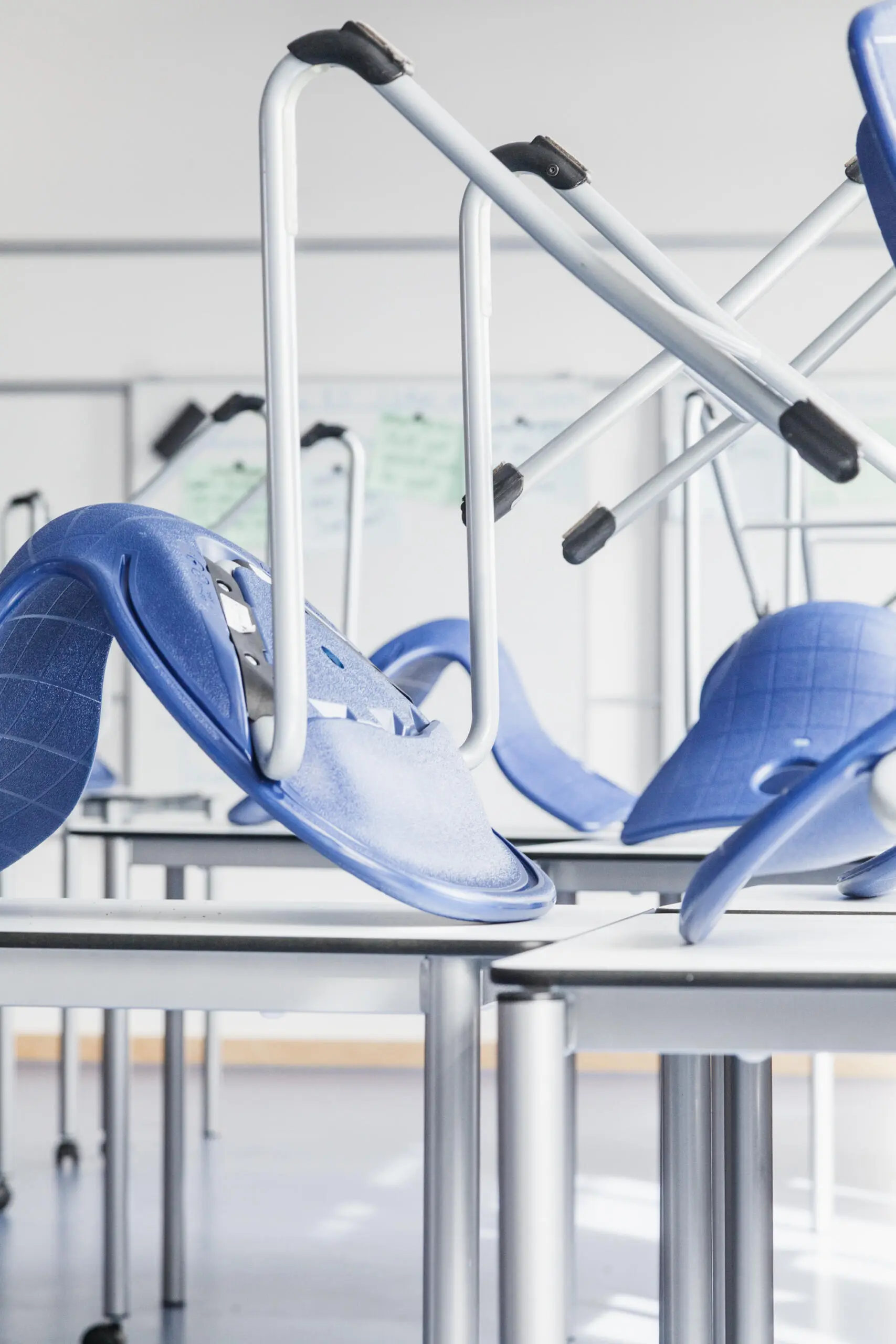 Unternehmensfotografie: Detailaufnahme von Stühlen auf Tischen in einem hellen Raum.