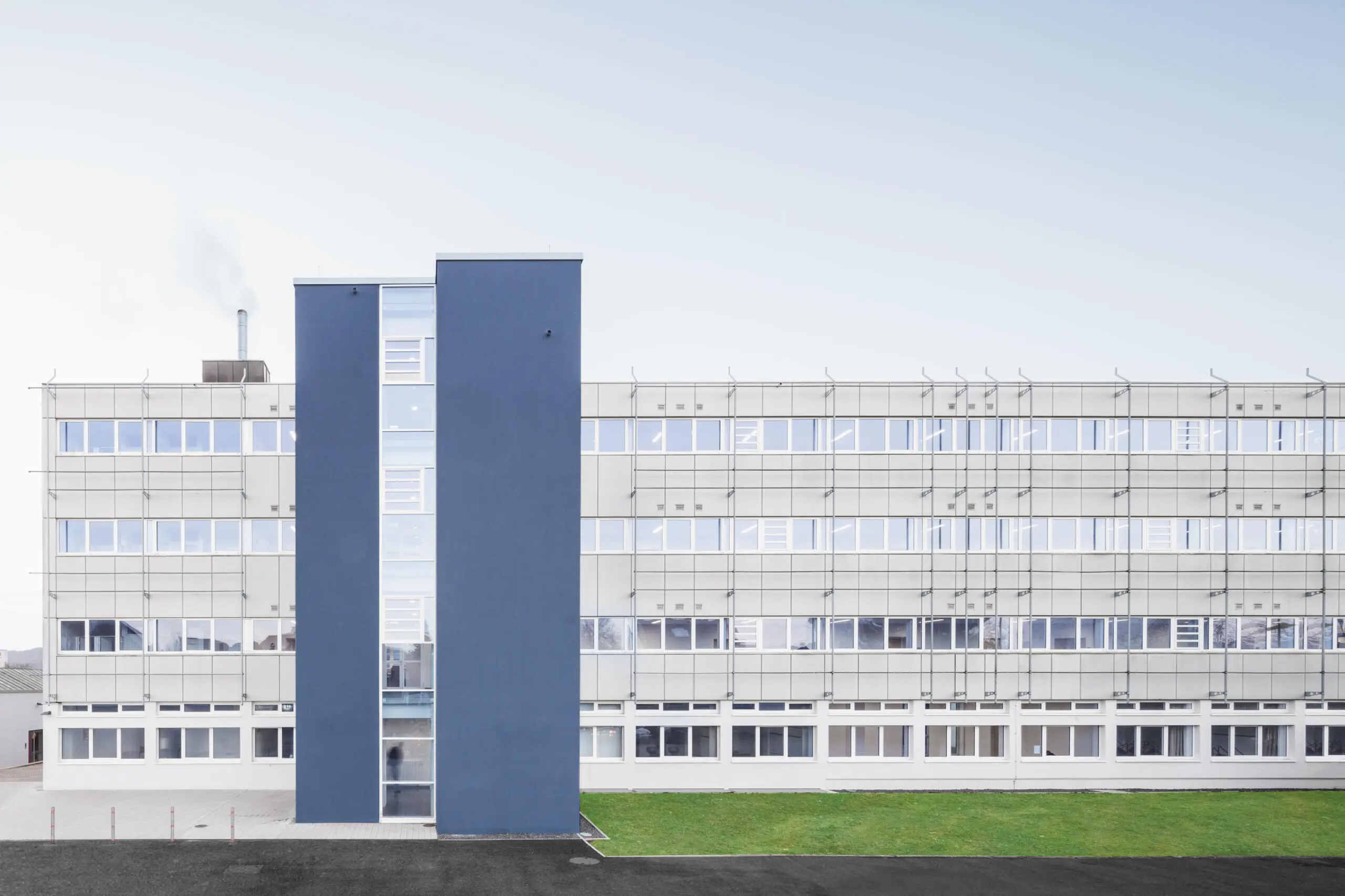 Gebäudefotografie: Fassade eines Bürogebäudes mit blauen Elementen und Fensterreihen.