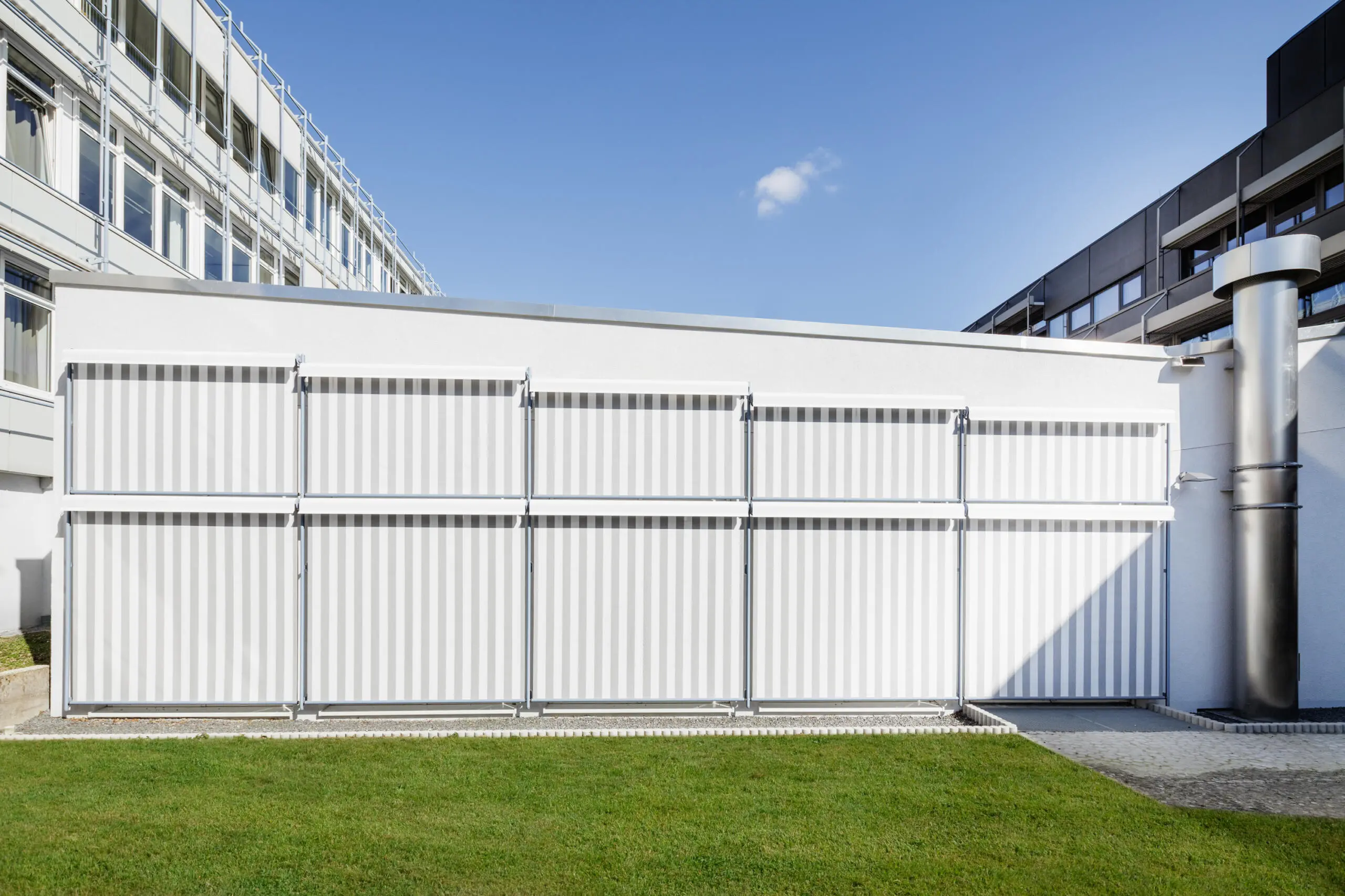 Architekturfotografie: Außenansicht eines Gebäudes mit Fassade und vertikalen Lamellen.