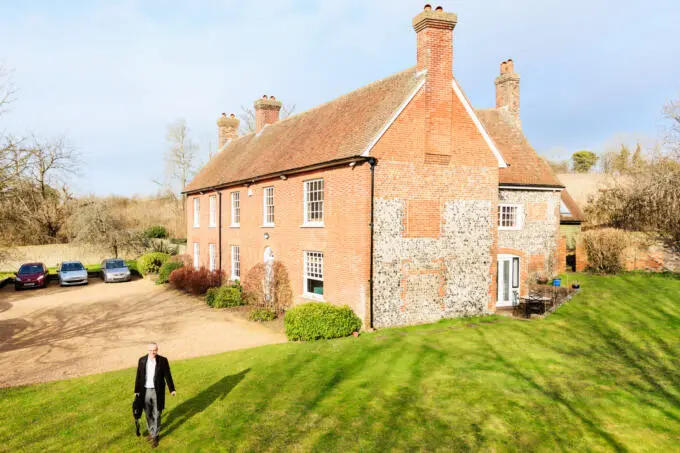 Exterior architectural photography of a historic brick and stone building with well-maintained grounds.