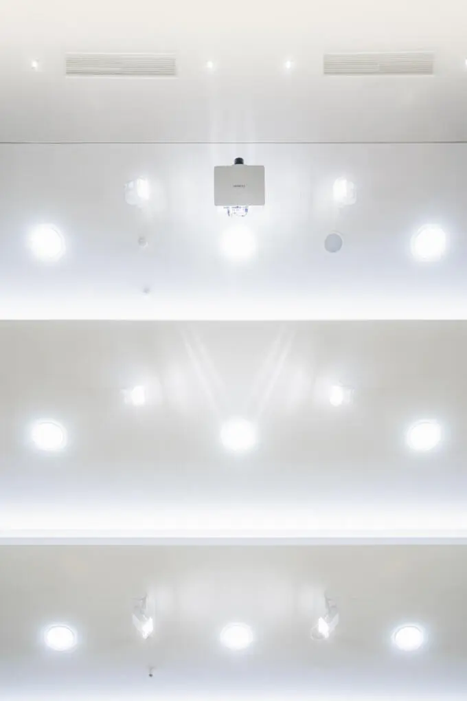 Modern ceiling with recessed lighting and projector. Interior architecture photography.