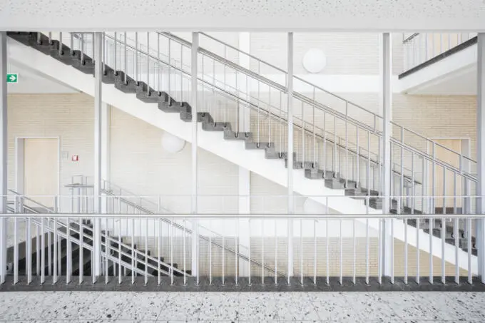 Innenaufnahme Treppenhaus: Architekturfotografie von Treppen mit Geländer und Wandverkleidung.