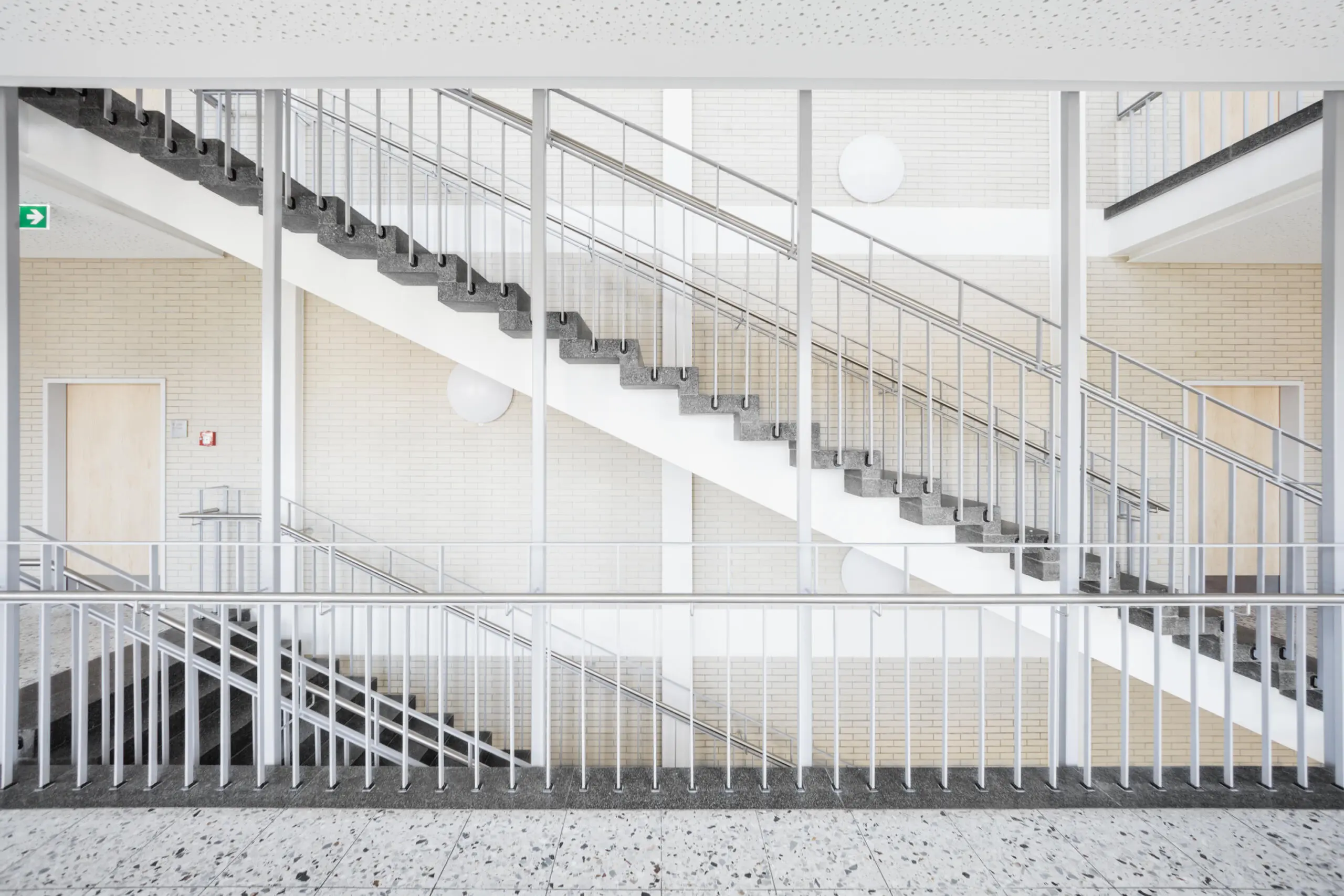 Innenaufnahme Treppenhaus: Architekturfotografie von Treppen mit Geländer und Wandverkleidung.