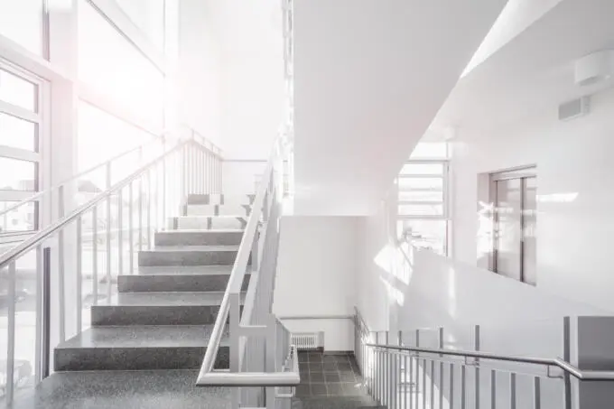 Innenaufnahme: Treppenhaus mit Tageslicht und Metallgeländer, Architekturfotografie.