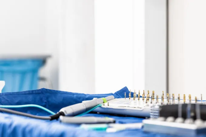 Nahaufnahme von sterilen zahnärztlichen Bohrern und einem Handstück auf blauen Tüchern.