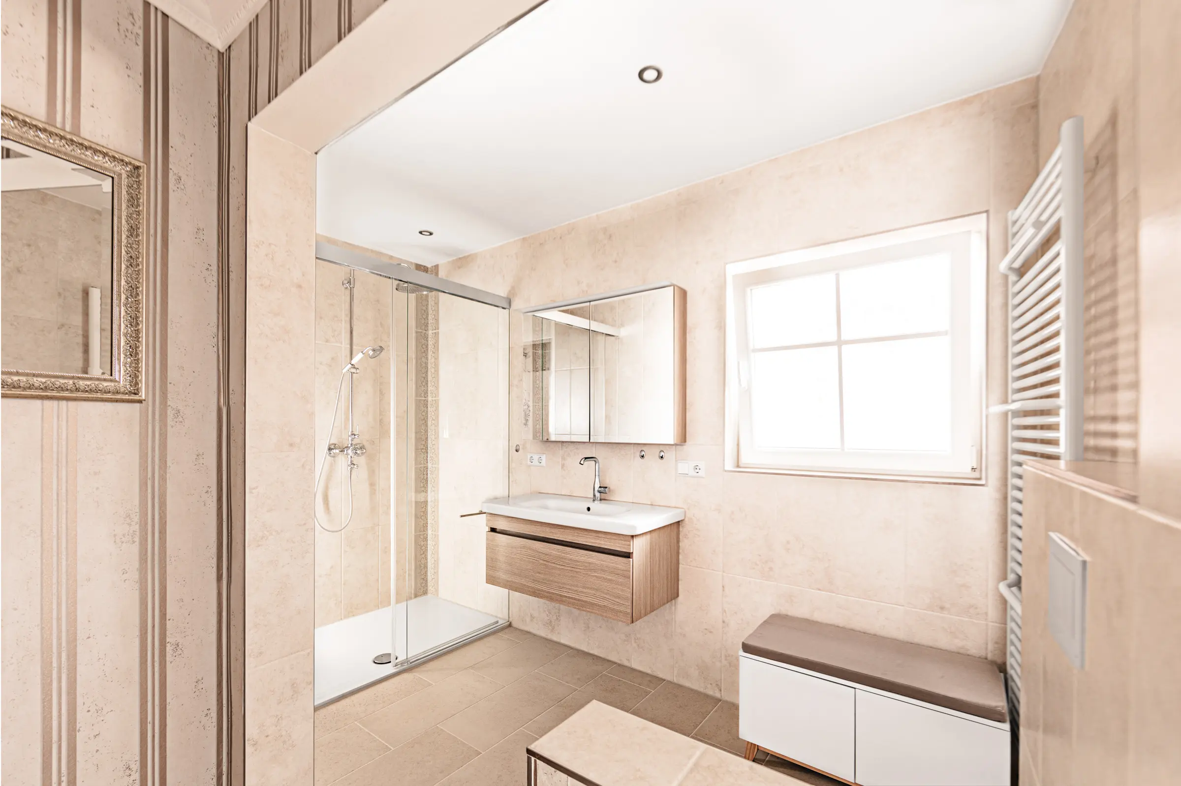 Modernes Badezimmer mit beigen Wand- und Bodenfliesen, Glasdusche und Waschtisch