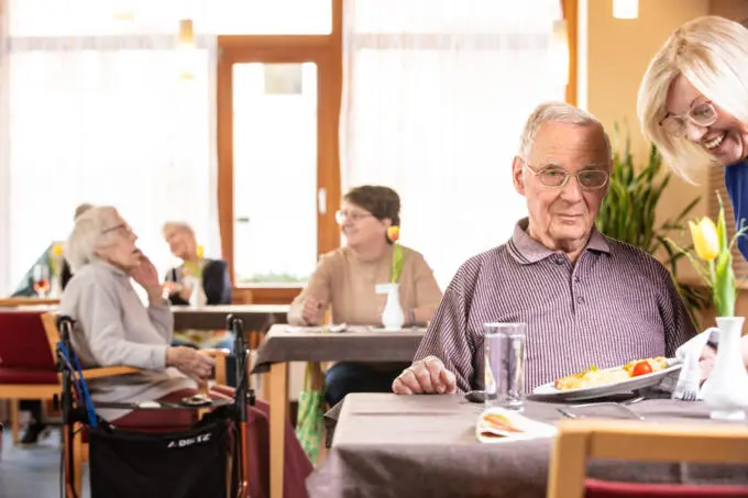 Senioren beim Mittagessen in einem hellen Gemeinschaftsraum.