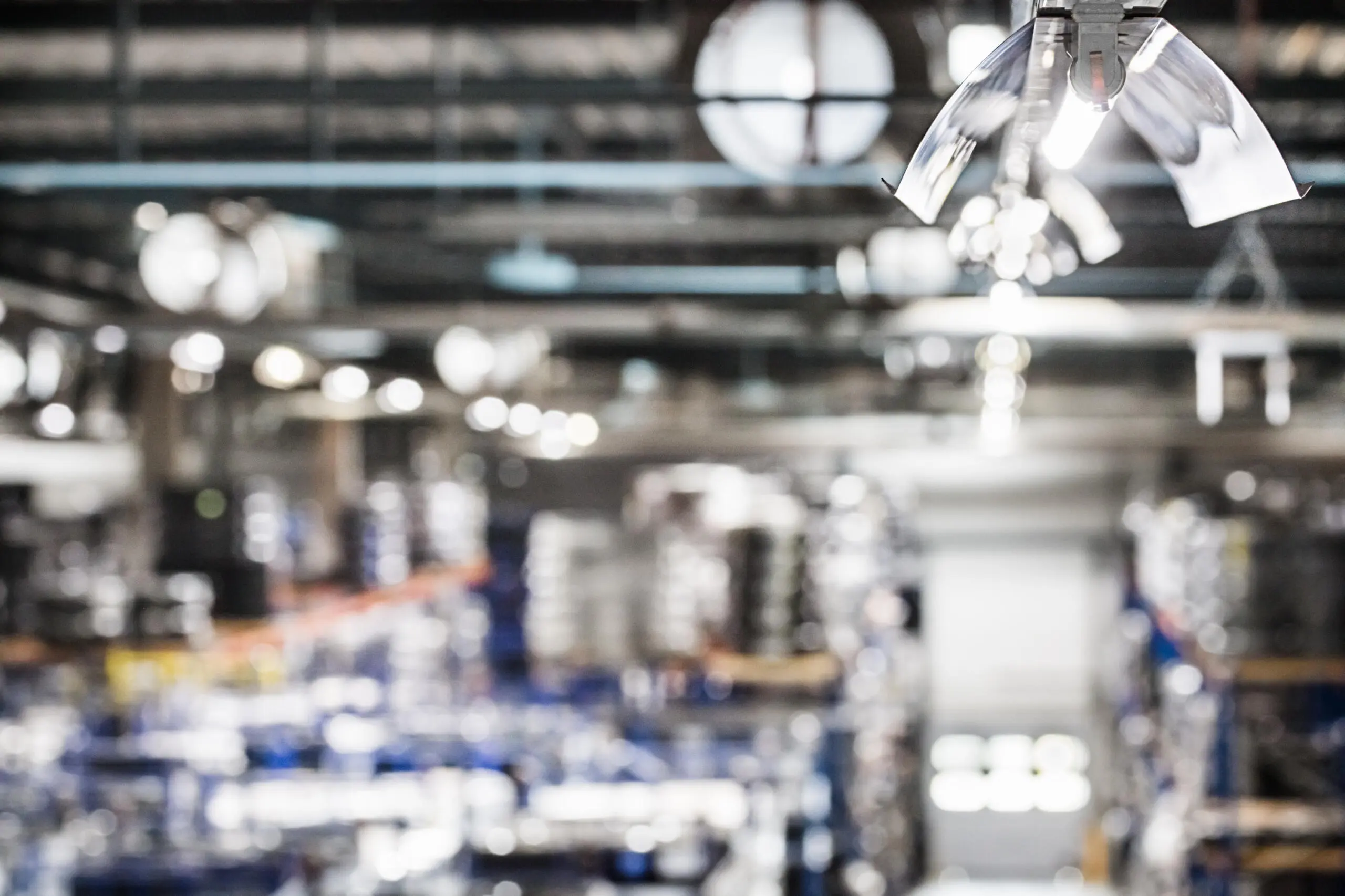 Unscharfe Ansicht einer Industriehallendecke mit Beleuchtung und Lüftungssystemen