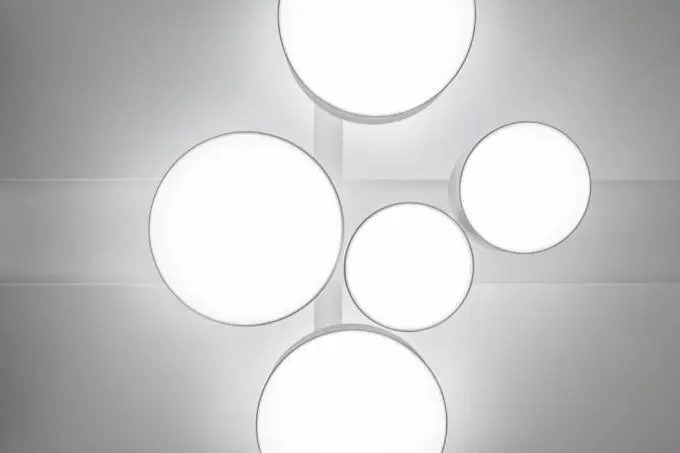 Abstrakte Ansicht runder weißer Deckenleuchten in minimalistischer Anordnung an einer grauen Decke