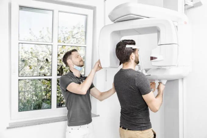Zahnarzt führt Röntgenuntersuchung mit moderner Technik durch.
