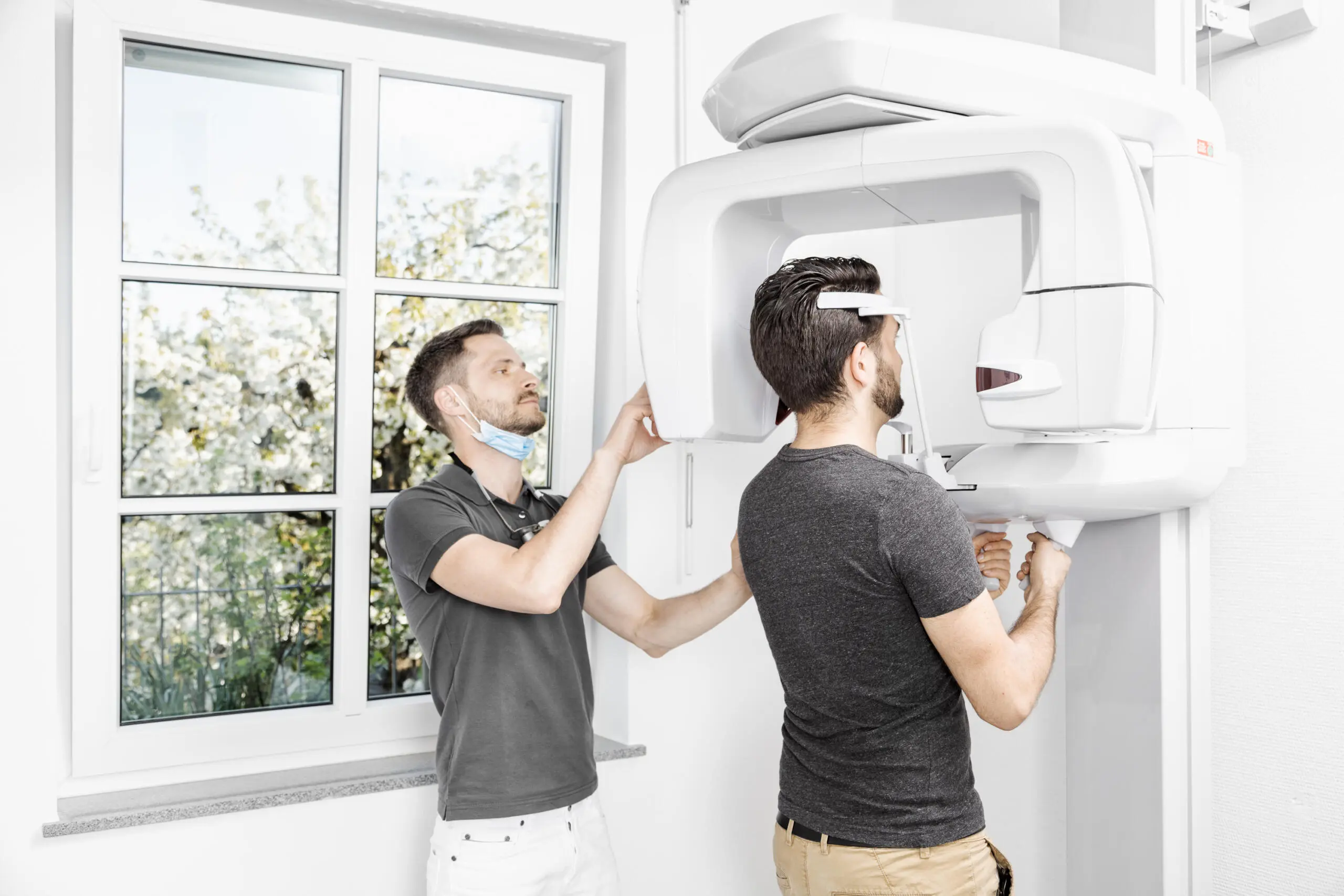 Zahnarzt führt Röntgenuntersuchung mit moderner Technik durch.