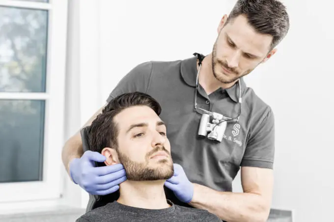 Zahnarzt untersucht Patient. Unternehmensfotografie aus Karlsruhe.